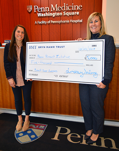 Lindsay Saling (Bryn Mawr Trust; on right) presenting a check to Emily Verdame (Penn).