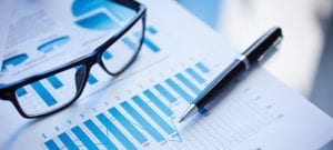 Image of a financial chart, eyeglasses, and pen