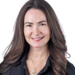 A headshot of associate associate Kate Duffy. She has long brown hair and is wearing a black shirt.