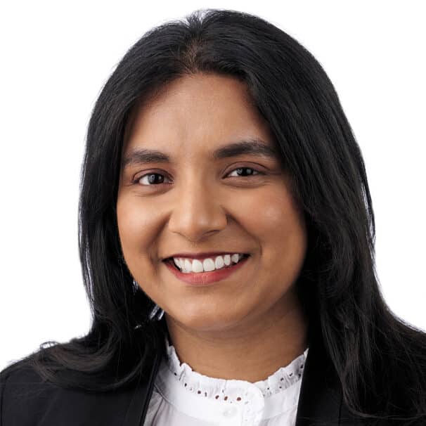 A headshot of associate Sony Mathew. She has long black hair and is wearing a lacy white collared shirt.