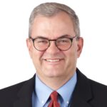 A headshot of associate David Stork. He is wearing black eyeglasses and a black suit.