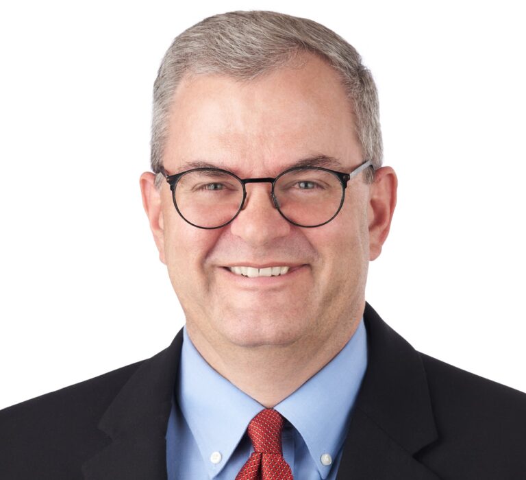 A headshot of associate David Stork. He is wearing black eyeglasses and a black suit.
