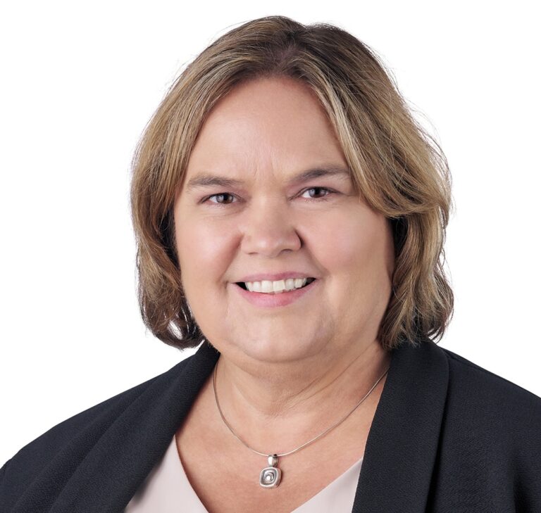A headshot of associate Lori Evans. She has short blonde hair and is wearing a black cardigan sweater.