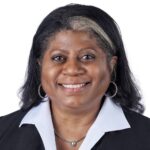 A headshot of associate Sheila Gibson. She has shoulder-length black hair and she is wearing a black blazer.