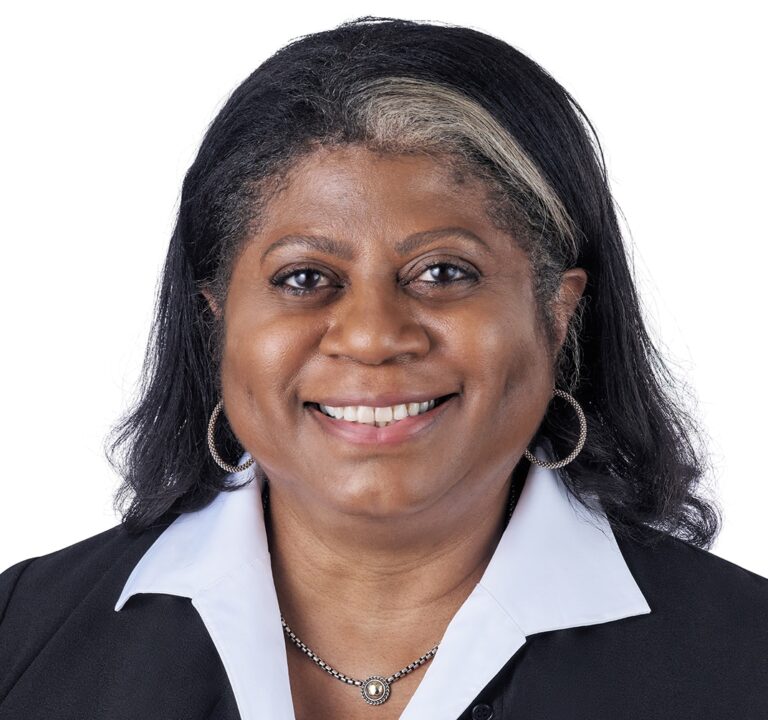 A headshot of associate Sheila Gibson. She has shoulder-length black hair and she is wearing a black blazer.