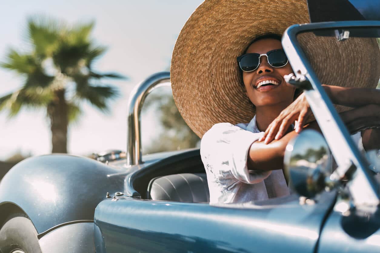 A woman driving a convertible car.