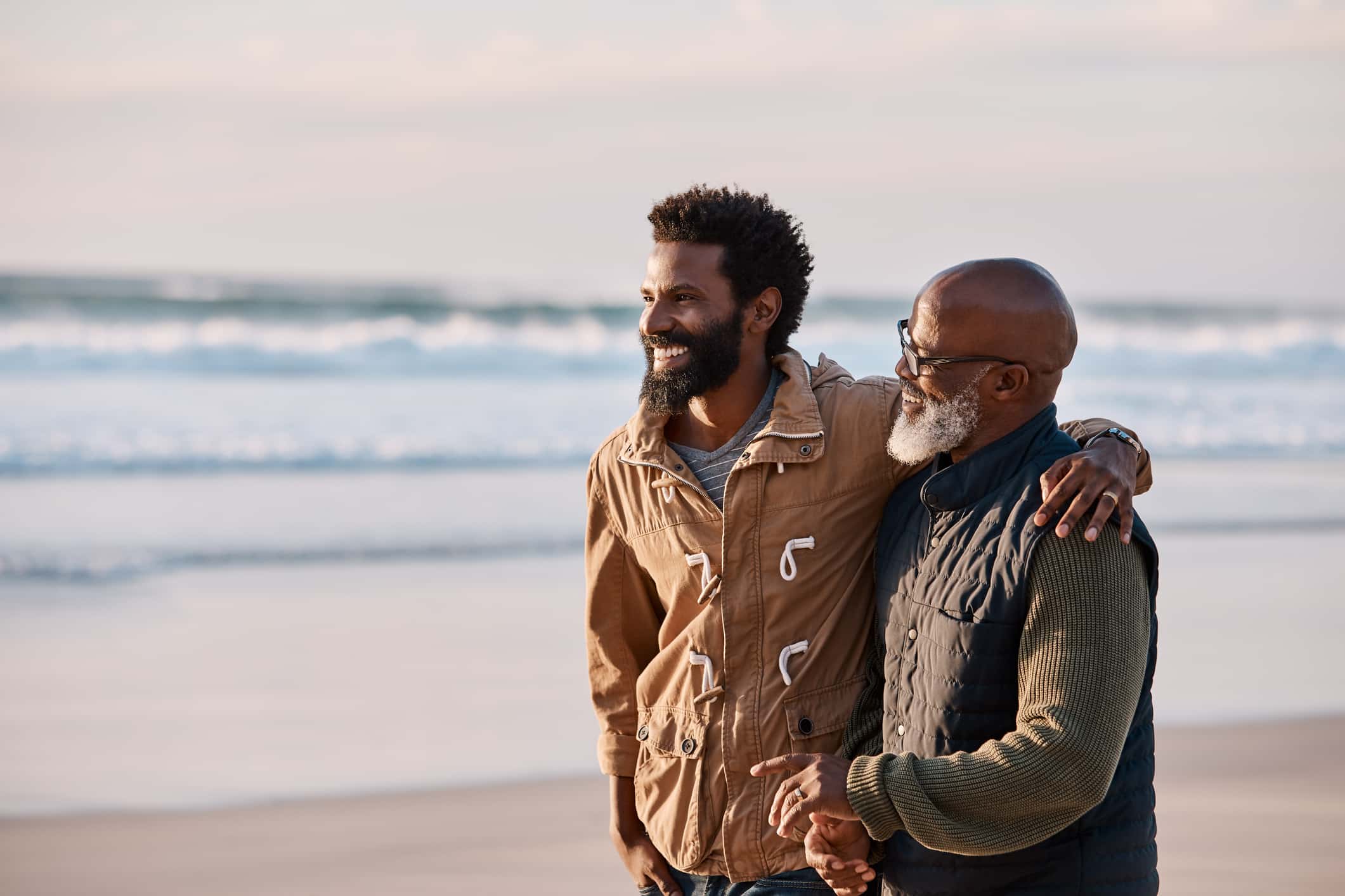 Father and son standing together on beach
